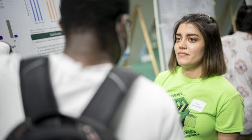 Woman talking to man at student expo