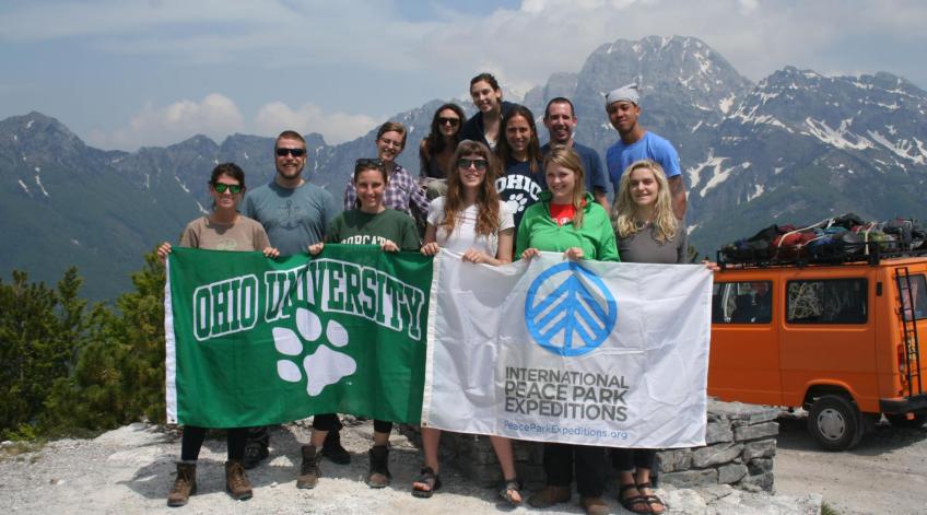 OHIO students on a mountain holding an Ohio University flag