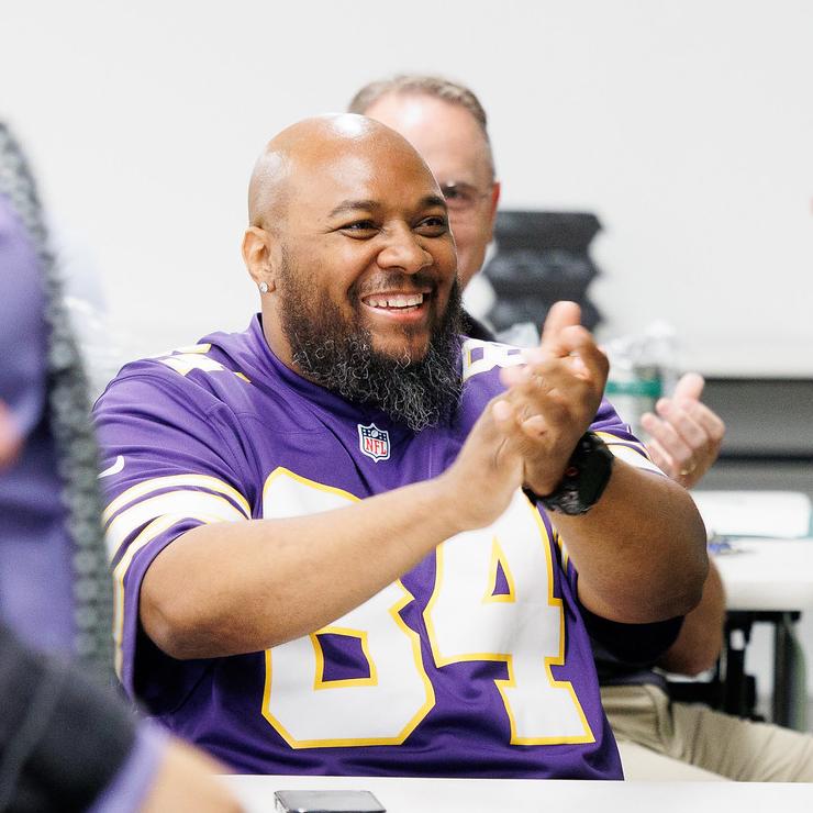 A man claps and smiles 