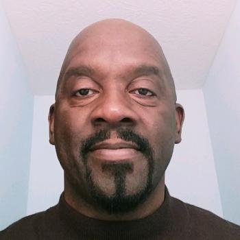 Professional headshot of Darryl Graves. A man looking at the camera with a goatee and wearing a black turtleneck.