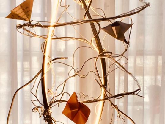 transforming trauma art installation features a metal sculpture and paper accents
